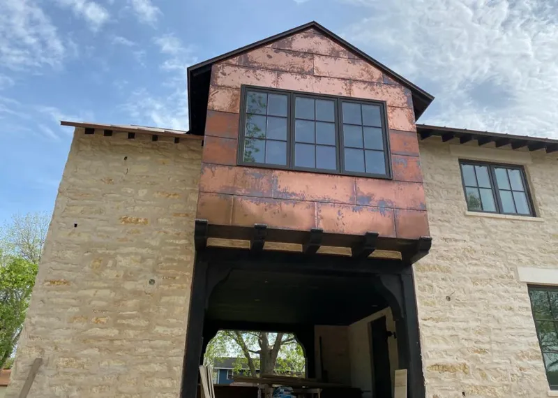 Copper metal panel facade on a stone building for Skylight Installation in Acushnet