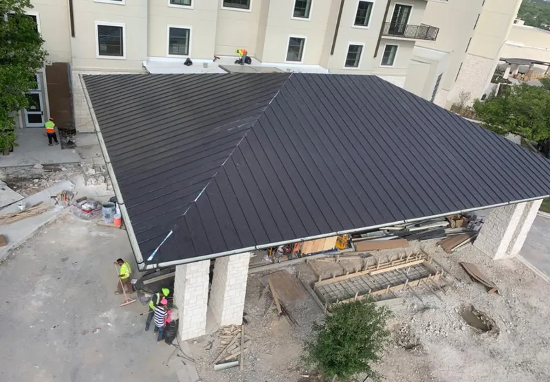 Metal roofing installation team working on a commercial building in Acushnet